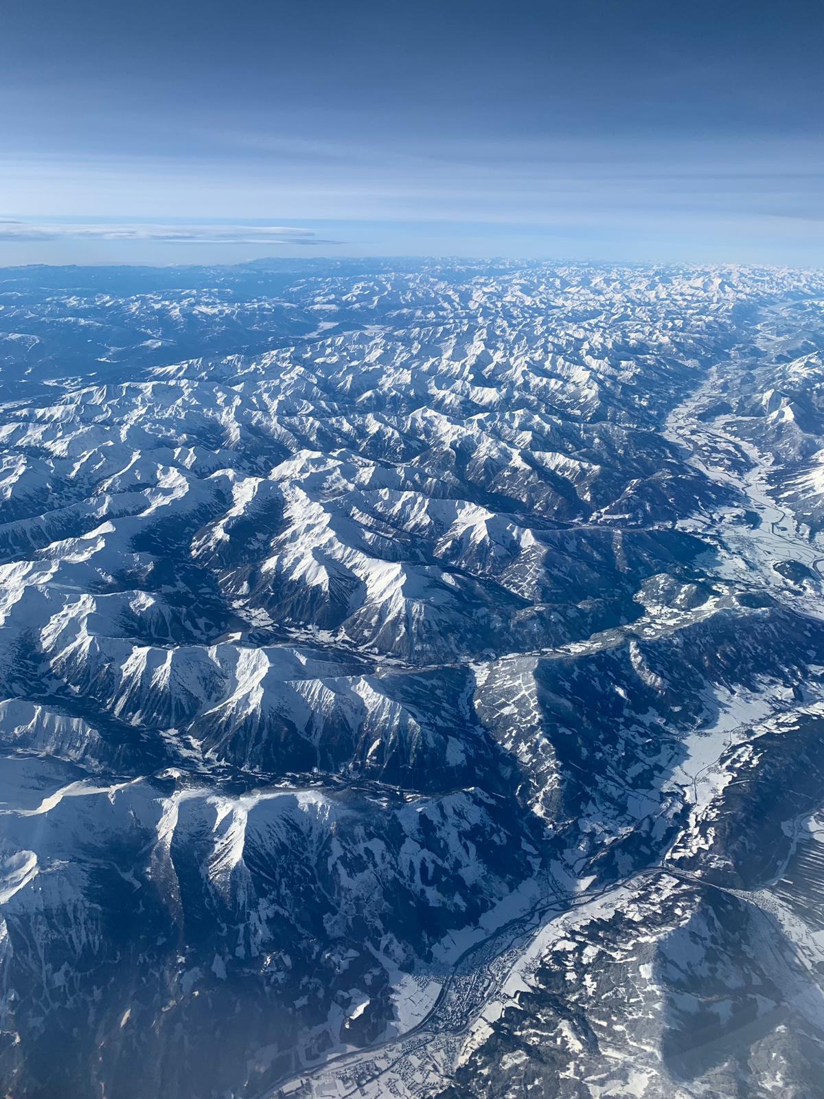 An aerial view across layered mountain ranges