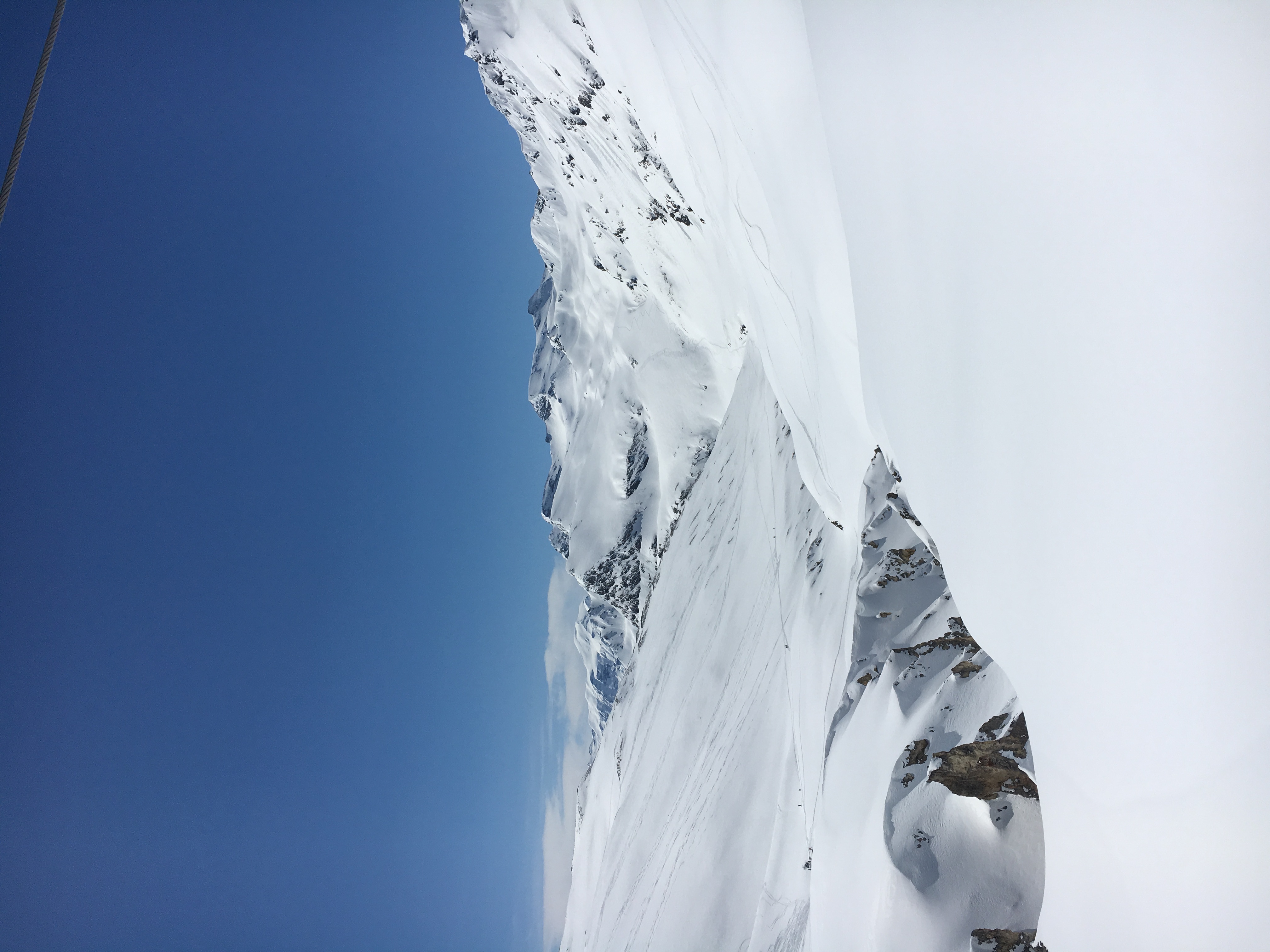 A wide snow basin opening between high peaks