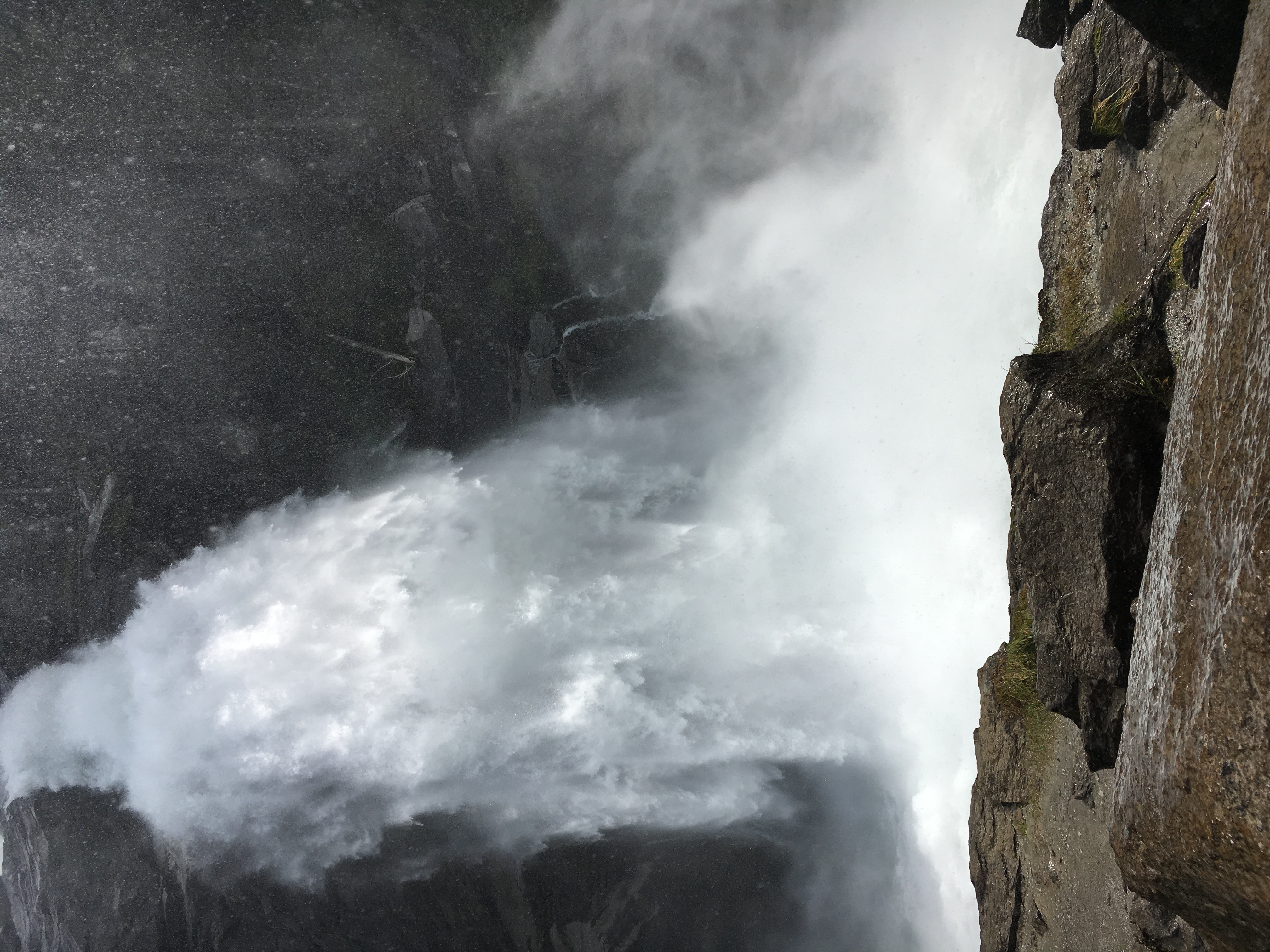 A mountain waterfall plunging into a forested ravine